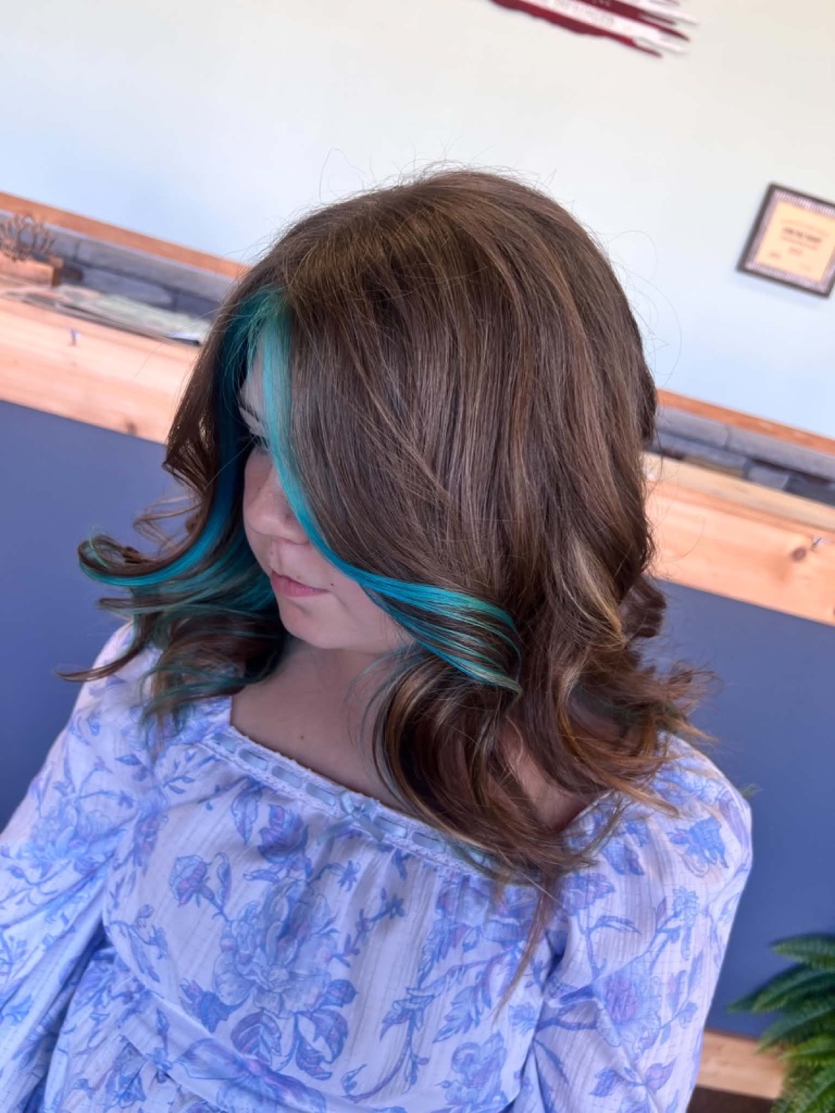 Brunette waves with teal face-framing color by Jade Ferguson